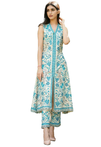 Woman in embroidered tunic and pants posing outdoors in a garden setting.